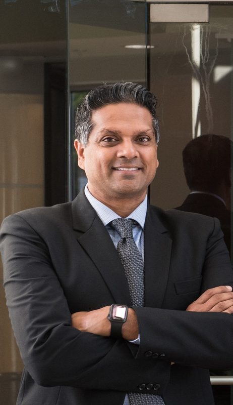 Arpan Nalin Patel standing with his arms crossed in a dark suit outside a glass entrance in Langhorne, Pennsylvania.